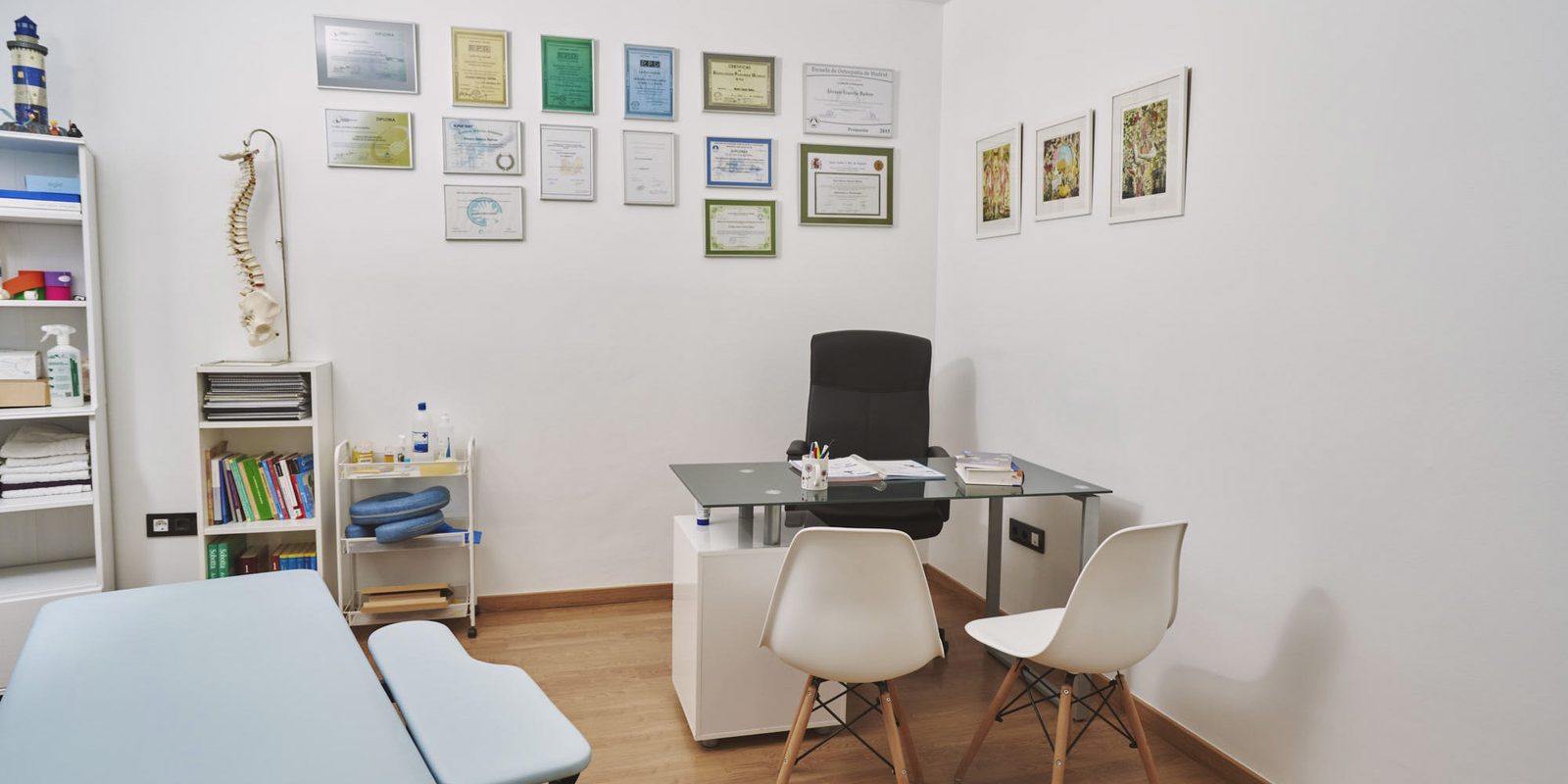 Consulta de Clínica Silos con escritorio, dos sillas y diplomas en la pared.