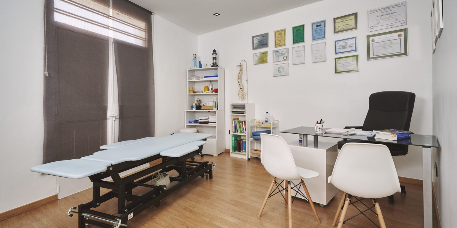 Sala de fisioterapia de Clínica Silos con camilla, escritorio y sillas.